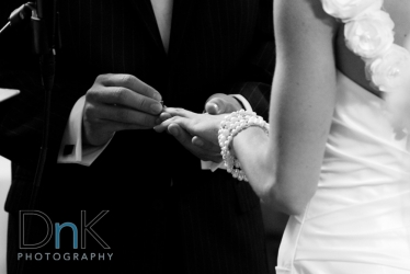 Black and White wedding picture groom putting ring on bride