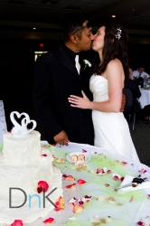 bride and groom kiss by cake